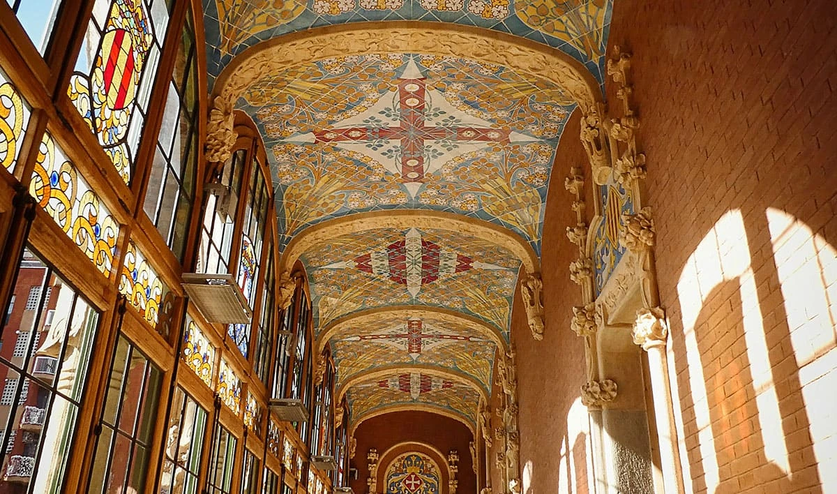 Corredor con vitrales y mosaicos modernistas del Hospital de Sant Pau en Barcelona, diseñado por Domènech i Montaner